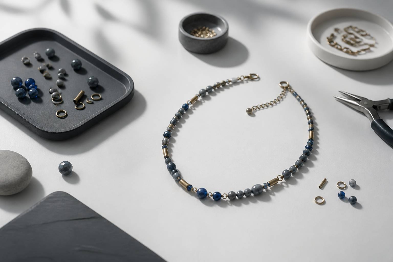 Table d'atelier avec perles, maillons et outils de bijoutier