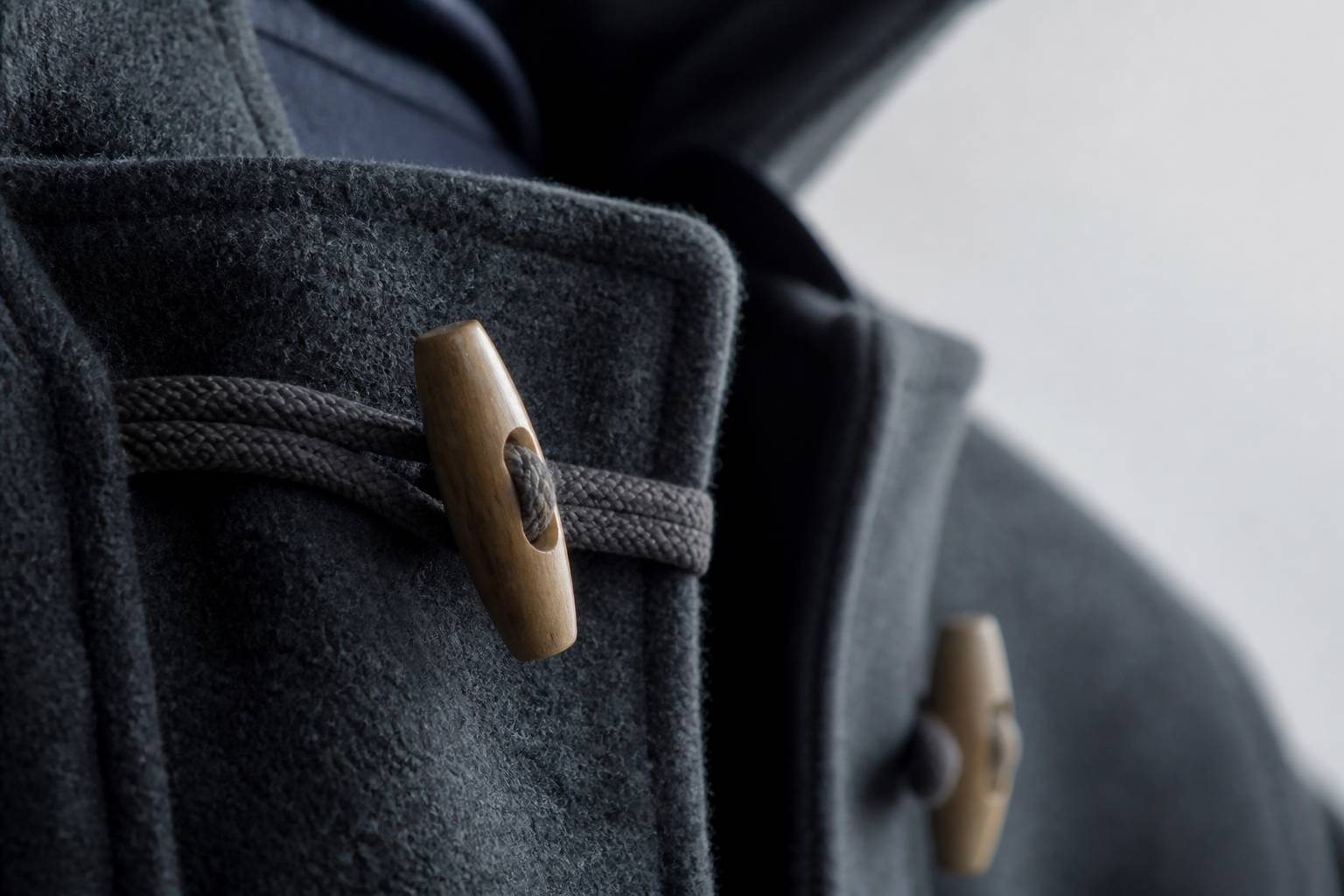 Attaches en bois et cordons d'un duffle-coat en laine épaisse