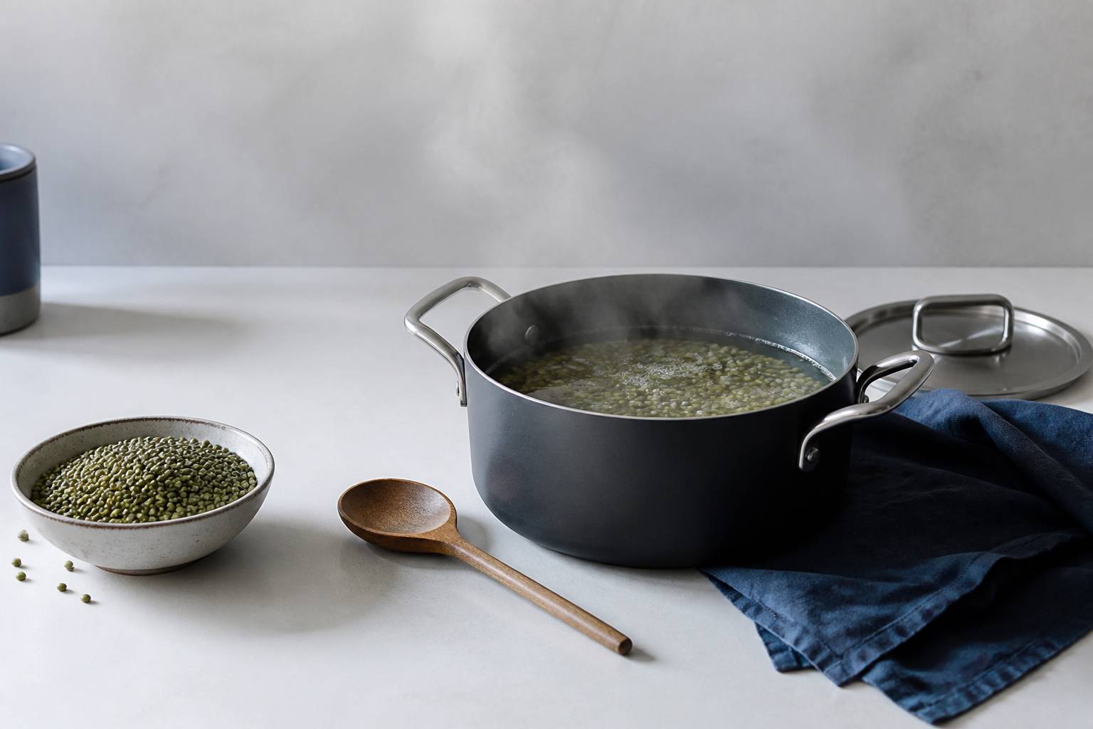 Casserole de lentilles vertes en cuisson avec bol de lentilles sèches