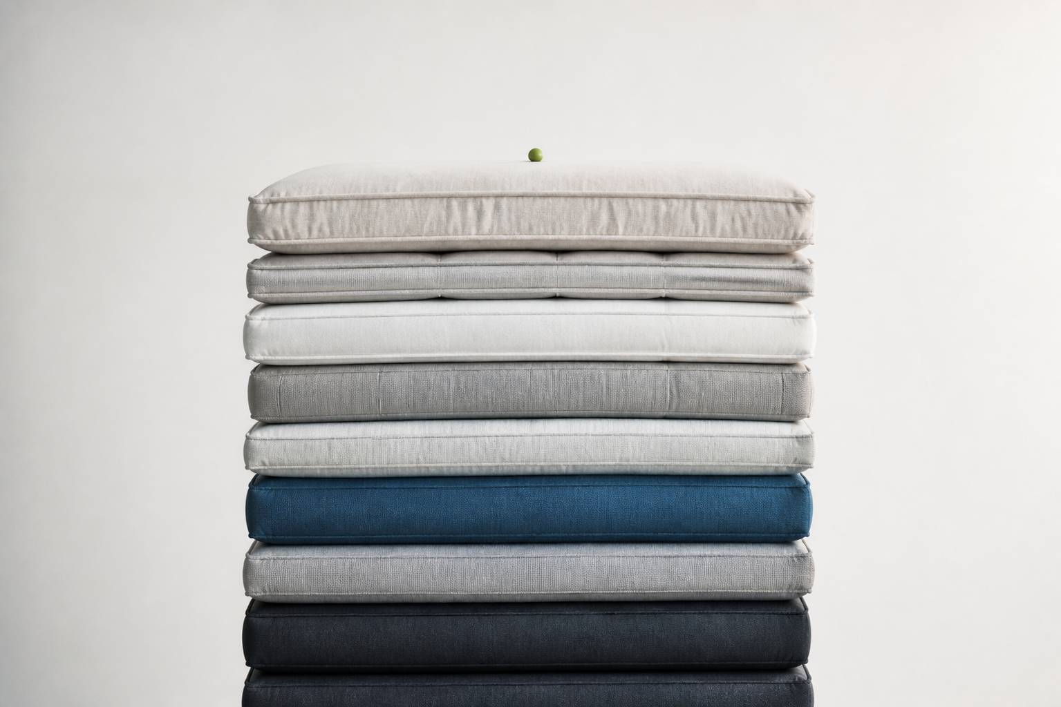 Empilement de matelas moelleux surmonté d'un petit pois dans une lumière douce